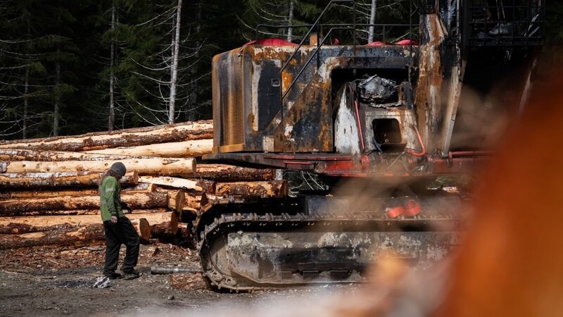 Bush Mechanic Adrian Bailey inspects a burnt yarder at the Cypress Creek Logging worksite. – Bild: Warner Bros. Discovery /​ Paul Taggart