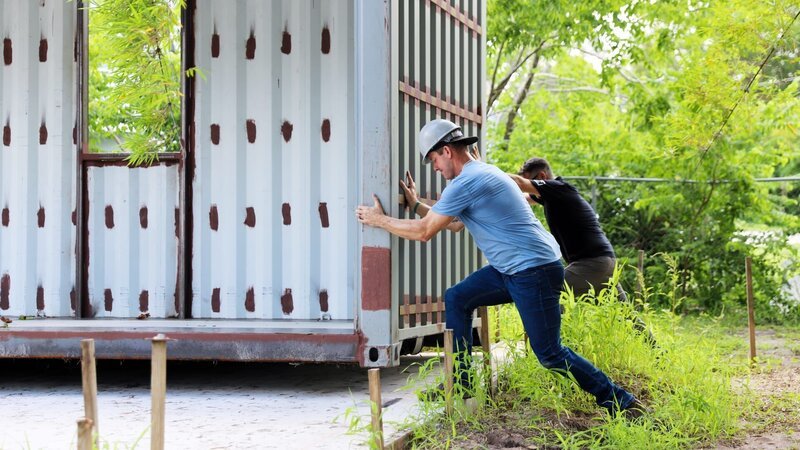 Brian Kleinschmidt helps move the container unit into place, as seen on 100 Day Dream Home, Season 6. – Bild: Warner Bros. Discovery