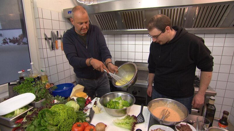 Frank Rosin (l.) gibt seinem neuesten Schützling ein Kochcoaching und zeigt ihm, wie man richtig gute Mettburger und Cesar Salads macht … – Bild: Kabel Eins