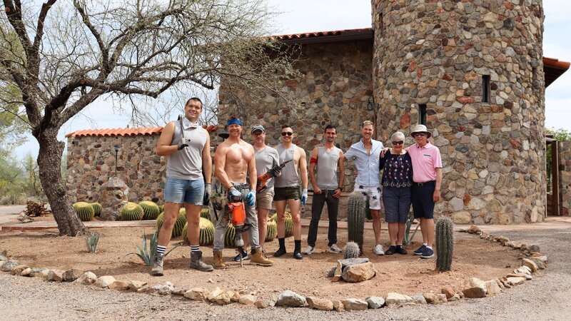 From left to right: Kevan Sullivan, Jason Leo Curley, Christopher Allen, Keith Reeves, Kristopher Herring, Ian K. Macgillivray, Barbara Macgillivray, and Tom Macgillivray pose for a picture outside of House 3, Castle Hill, Hero, as seen on My Lottery Dream Home, Season 17. – Bild: Warner Bros. Discovery