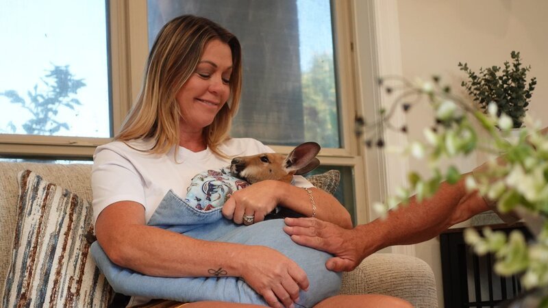 Marsha smiling while sitting on the couch holding the baby Kangaroo – Bild: TLC (DEUT)