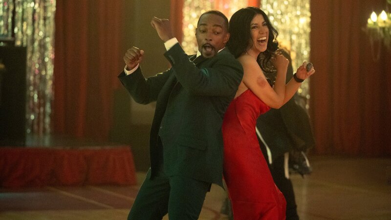 Auf der Wintersonnenwende-Party wird ausgelassen gefeiert. Während John (Anthony Mackie, l.) sich am Buffet bedient und den Abend genießt, betrachtet Quiet (Stephanie Beatriz, r.) das bunte Treiben mit Skepsis. – Bild: ZDF