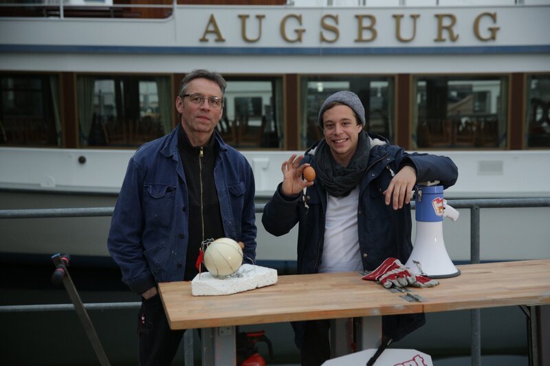 Checker Tobi mit Bootstechniker Bertl Leitner (links). – Bild: BR/​megaherz gmbH/​Mathias Hagn