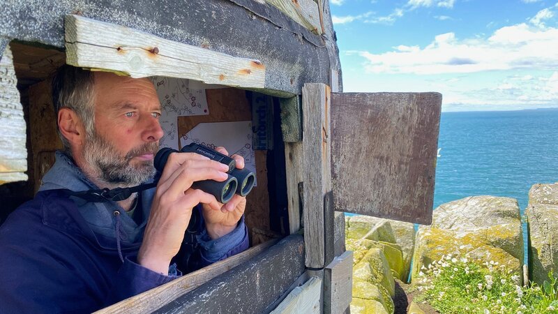 Vogelwart Mark Newell im Beobachtungsstand auf der Isle of May – Bild: SRG SSR/​Autentic