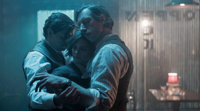 Charlotte Ritter (Liv Lisa Fries, Mitte), Gräf (Christian Friedel, li.) und Jacky (Max Mauff, re.) tanzen eng umschlungen im Koppeneck zusammen. – Bild: Frédéric Batier/​X Filme Creative Pool/​ARD Degeto Film/​WDR/​SWR/​HR/​Radio Bremen/​Beta Film