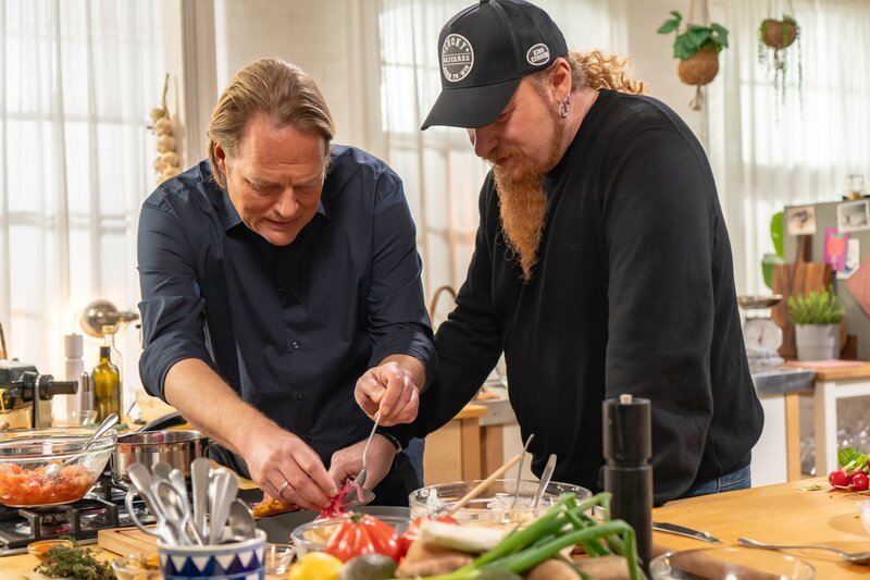 Björn Freitag (li.) hat ein ausgefallenes Rezept mitgebracht. Er kocht mit Lucki Maurer (re.) Kartoffelwaffel-Sandwiches mit Obazda. – Bild: WDR/​2bild GmbH/​Christopher Nußbaumer