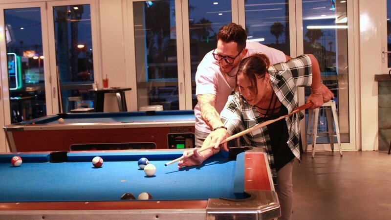 Joshua Weinstein smiles and helps Kimberly Menzies shoot the cue ball in a bar. – Bild: TLC (DEUT)