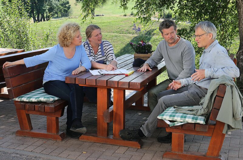 v.li. Bea (Christiane Brammer), Evelyn (Catharina Kottmeier), Markus (Sebastian Mirow) und Karl (Peter Schell) besprechen die Pläne zur Molkerei. – Bild: SWR/​Johannes Krieg