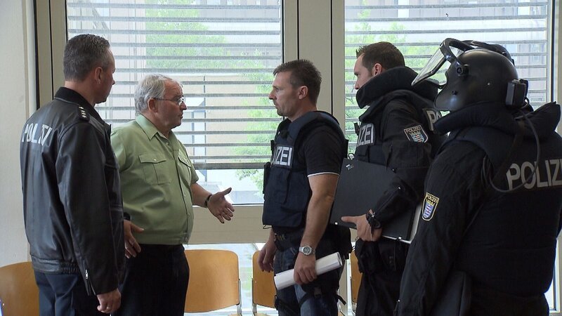 Einsatzleiter Klaus Behrendt (3. v. li.) und seine Männer sprechen mit dem Justizbeamten (2. v. li.). – Bild: RTL 2 (DE)