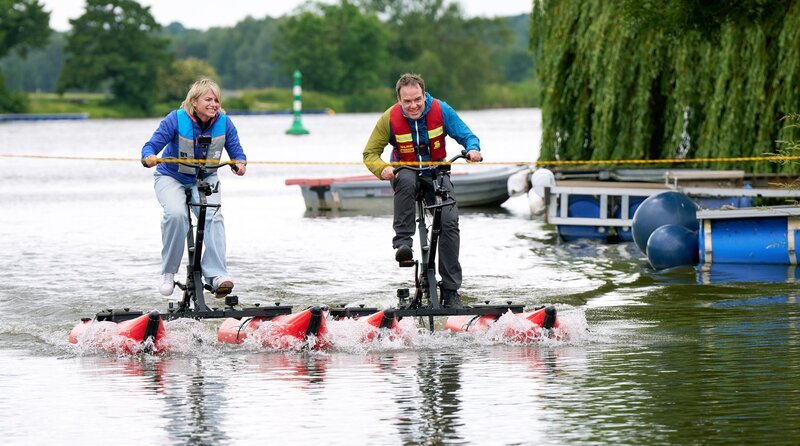 Moderatorin Sabine Heinrich (l) liefert sich zum Finale mit ihrem Kollegen Fabian Raphael ein Wettrennen auf der Weser. – Bild: WDR/​Guido Engels