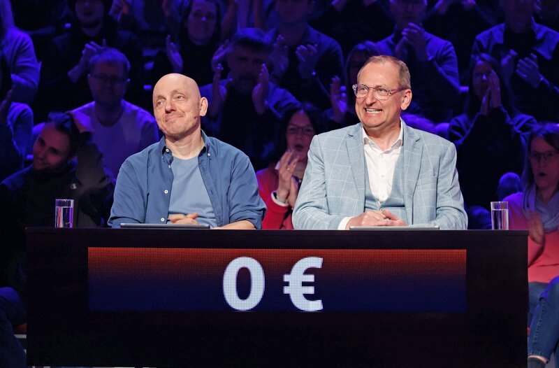 Rateteam-Kapitän Bernhard Hoëcker (l.) mit Komödiant und Schauspieler Volker Heißmann (r.). – Bild: ARD/​Morris Mac Matzen