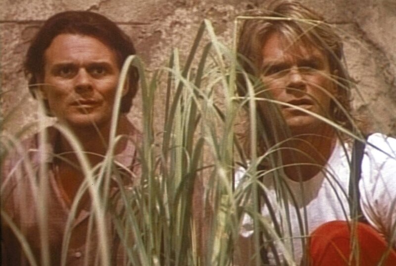Der Profikiller Murdoc (Michael des Barres, l.) und MacGyver (Richard Dean Anderson, r.) beobachten das Clubhaus von Nicholas Melman. – Bild: Paramount Pictures