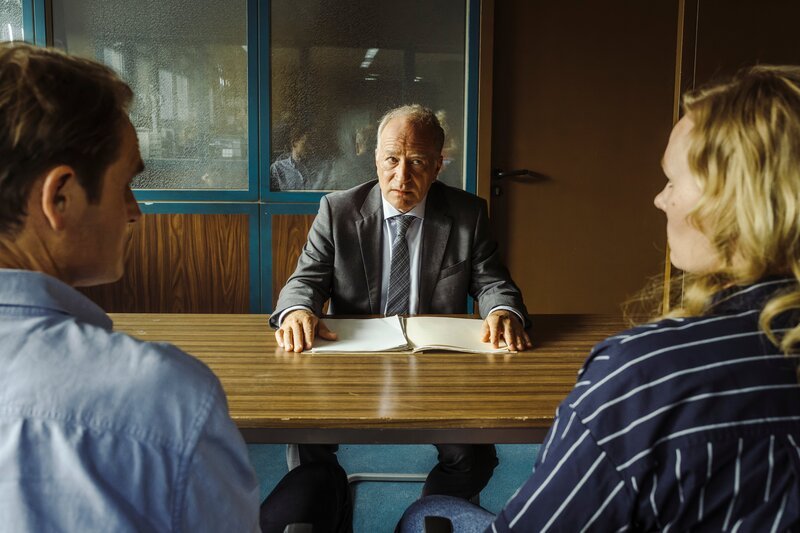 Von links: Felix Voss (Fabian Hinrichs), Dr. Mirko Kaiser (Stefan Merki) und Emmy Rathgeber (Rosalie Thomass). Kaiser bespricht sich mit den Kommissaren und prüft Emmy. – Bild: Hendrik Heiden /​ BR; Claussen+Putz Filmproduktion GmbH /​ BR/​Claussen+Putz Filmproduktion GmbH/​Hendrik Heiden