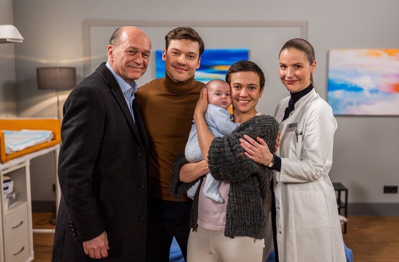 Familienbild mit Baby (v.l.n.r.): Wolfgang Berger (Horst Günther Marx), Florian Osterwald (Lion Wasczyk), Dr. Rebecca Krieger (Milena Straube) mit Baby und Dr. Julia Berger (Mirka Pigulla). – Bild: ARD/​Michael Kremer