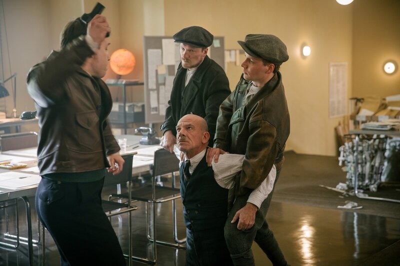 Der Chefredakteur Heymann (Martin Wuttke, 2. v. re.) wird von Fritz (Jacob Matschenz, 3. v. re.) und seinen Schergen bedroht und unter Druck gesetzt. – Bild: ORF/​Beta Film/​X Filme Creative Pool GmbH/​Frédéric Batier