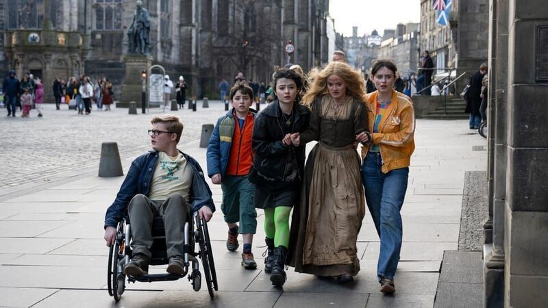 Iain, Martin, Jenna und Emily bringen die gerettete Margery in Sicherheit. – Bild: NDR/​Black Camel/​Media Valley