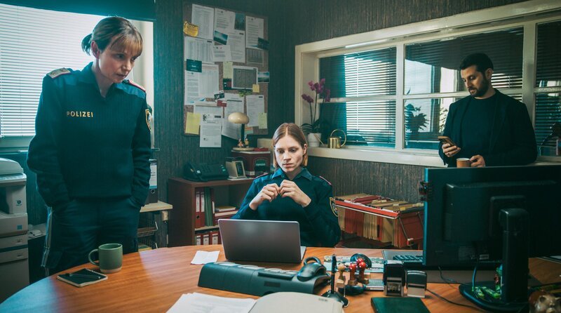 In der Polizeidienststelle untersucht Elli (Anna Wagner, Mitte) den Laptop des Lehrers Bichler. Pia (Julia Koschitz) und Tarek Moser (Bardo Böhlefeld) warten auf die Ergebnisse. – Bild: ARD Degeto Film/​ORF/​Mona Film/​Victoria Herbig