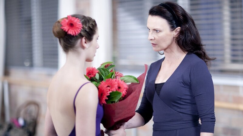 Ein heimlicher Verehrer beschenkt Tara (Xenia Goodwin, l.) mit Blumen. Allerdings stellt sich heraus, dass die Blumenaktionen von Kat ausgehen und einer Verkupplung dienen sollen. Miss Raine (Tara Morice, r.) empfindet dies natürlich als Störung ihrer Tanzstunde. – Bild: ZDF