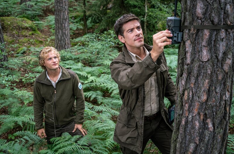 Gemeinsam mit seiner Aushilfe Leon Fechner (Justus Czaja, l.) installiert Nationalpark-Ranger Jonas Waldek (Philipp Danne, r.) Kameras, um die Greifvögel zu beobachten. – Bild: MDR/​ndF/​Uwe Frauendorf /​ MDR/​HA Kommunikation