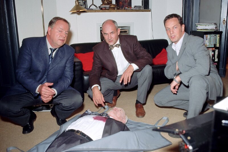 Tatortbesichtigung: Die Kommissare Kehler (Wolfgang Bathke, li.) und Bongartz (Max Gertsch) wollen von Gerichtsmediziner Duhler (Klaus Schindler, Mi.) erste Untersuchungsergebnisse zum Mord an Daschner (Komparse). – Bild: RTLplus
