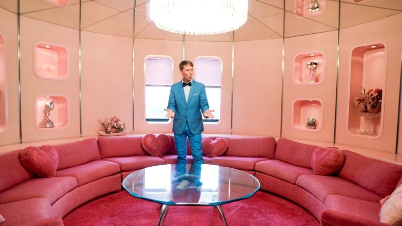 Host Jack McBrayer in the rotunda at the Pretty in Pink house, as seen on Zillow Gone Wild, Season 3. – Bild: Warner Bros. Discovery