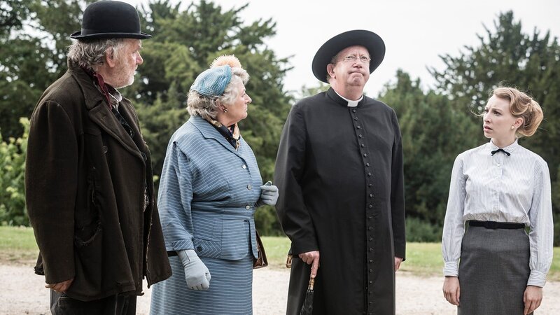 Blind Arry (Alan Williams), Mrs McCarthy (Sorcha Cusack), Father Brown (Mark Williams) und Eddie (Katie Buchholz) vermuten, dass Bunty in dem Gebäude der alten Druckerpresse gefangen ist. – Bild: AXN White