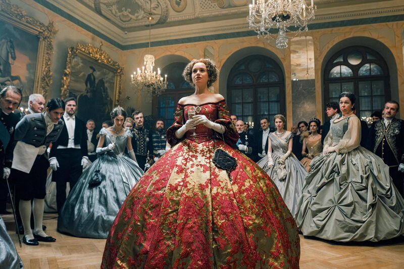 Gaunerin Walli (Pauline Werner) gibt sich auf dem Hofball als Gräfin aus. – Bild: ORF/​Beta Film/​RTL/​Story House Pictures/​Armands Virbulis