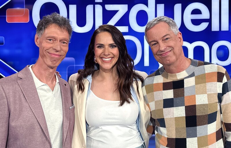 Moderatorin Esther Sedlaczek (M.) mit den Kandidaten des Teams „Quatsch“: Thomas Hermanns (r.) und Martin Schneider (l.). – Bild: ARD/ITV Studios Moderatorin Esther Sedlaczek (M.) mit den Kandidaten des Teams „Quatsch“: Thomas Hermanns (r.) und Martin Schneider (l.). – Bild: ARD/ITV Studios