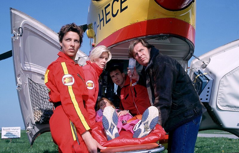 Pilotin Biggi (Sabine Petzl, li.), Notärztin Gabriele (Anja Freese, 2.v.li.), Sanitäter Ralf (Wolfgang Krewe) und Dr. Stefan Frank (Sigmar Solbach, re.) tragen Irene Kadenbach (Claudia Wenzel) in den Medicopter. – Bild: RTL /​ Elke Werner