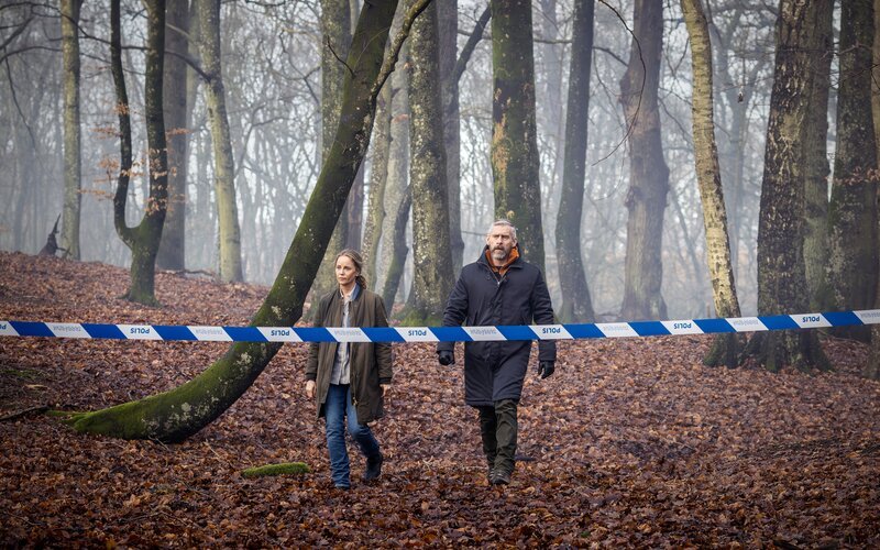 Iris (Sofia Helin, l.) und Jens (Håkan Bengtsson, r.) erkunden den Wald bei Gut Jacobsholm, in dem eine skelettierte Leiche gefunden wurde. – Bild: Carolina Romare /​ ZDF und Carolina Romare