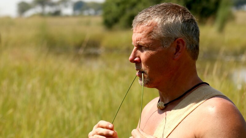 Joe hält in Namibia Gras in seinem Mund. – Bild: Discovery Communications