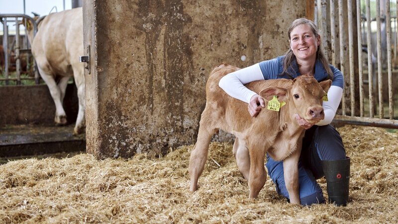 Kathrin Hauser mit einem Kalb im Stall. – Bild: Philipp Thurmaier /​ BR; megaherz GmbH /​ BR/​megaherz GmbH/​Philipp Thurmaier
