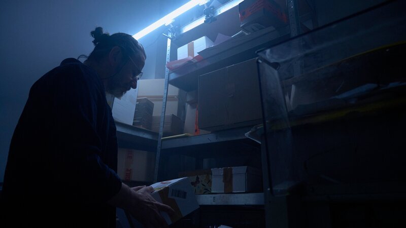 Gerold Brüning als ältere Version Joe Goldbergs, der unter falschem Namen in einem Paketshop arbeitet. – Bild: Jan Reiser /​ ZDF