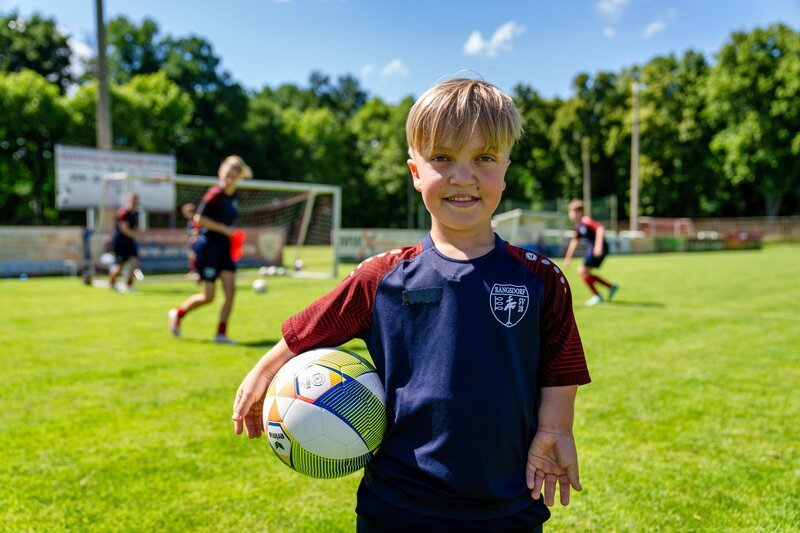 Benet will endlich ein Tor im Turnier schießen. Seine Fußballmannschaft unterstützt ihn dabei. Es ist nicht so leicht, denn Benet ist kleinwüchsig und er hat kürzere Beine, als seine Freunde im Team. – Bild: ZDF/​Florian Lippke