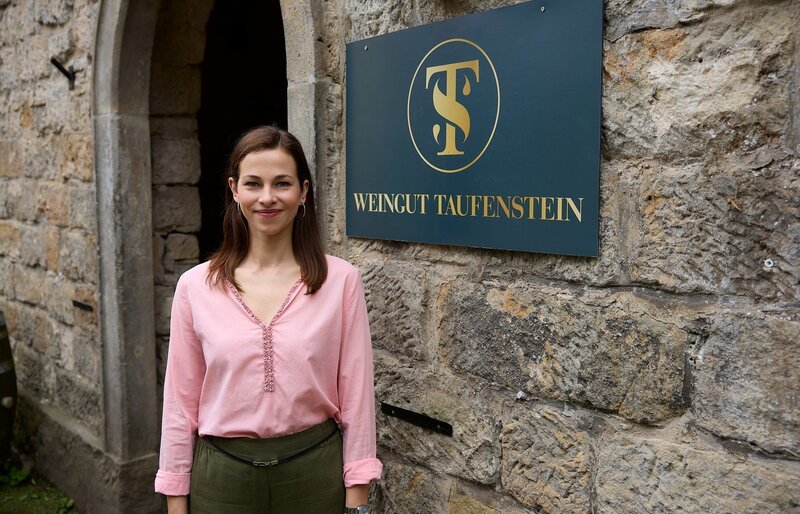 Isabel Stein (Marie Hacke) vor dem Eingang des Weinguts Taufenstein. – Bild: ARD/​Rudolf Wernicke