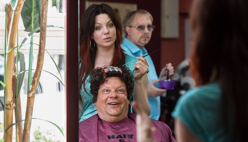 Clubbesitzer Mannie Schweers (Ulrich Bähnk) ist Kunde bei „Hair & Care“ und Jennifer (Katrin Ingendoh) kümmert sich um ihn. Ihr Chef Dietmar (Olli Dietrich) schaut ihr über die Schulter. – Bild: NDR/​Georges Pauly