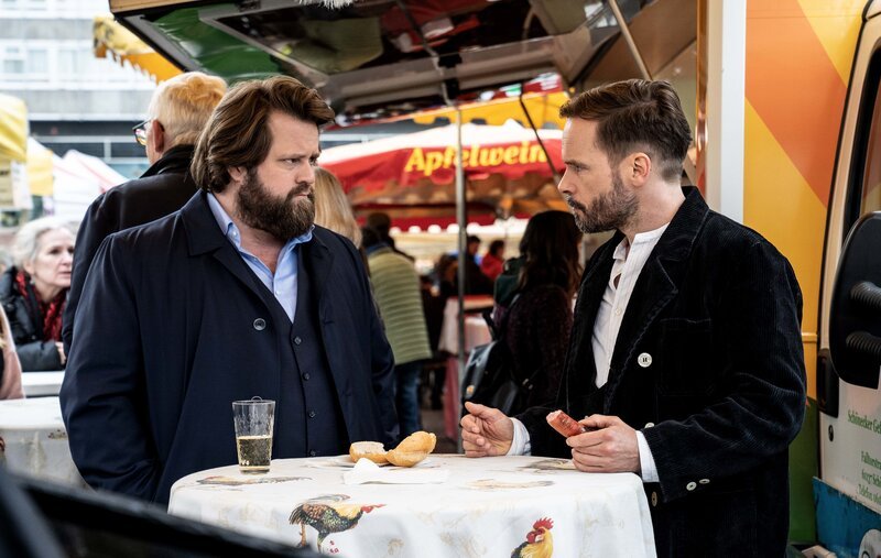 Leo Oswald (Wanja Mues, r.) hat sich als Handwerker auf der Walz auf dem Gutshof der Familie Kleiber eingeschlichen. Da seine Tarnung nicht auffliegen darf, können sich er und Benni Hornberg (Antoine Monot, Jr., l.) nur während einer Lieferfahrt von Leo kurz auf dem Konstabler Markt treffen und über den aktuellen Stand des Falls sprechen. – Bild: ZDF und Bettina Mueller