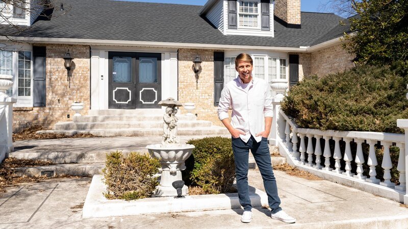 Host Jack McBrayer poses outside the Scarface Surprise Home, as seen on Zillow Gone Wild, Season 2. – Bild: Warner Bros. Discovery /​ Anders Krusberg