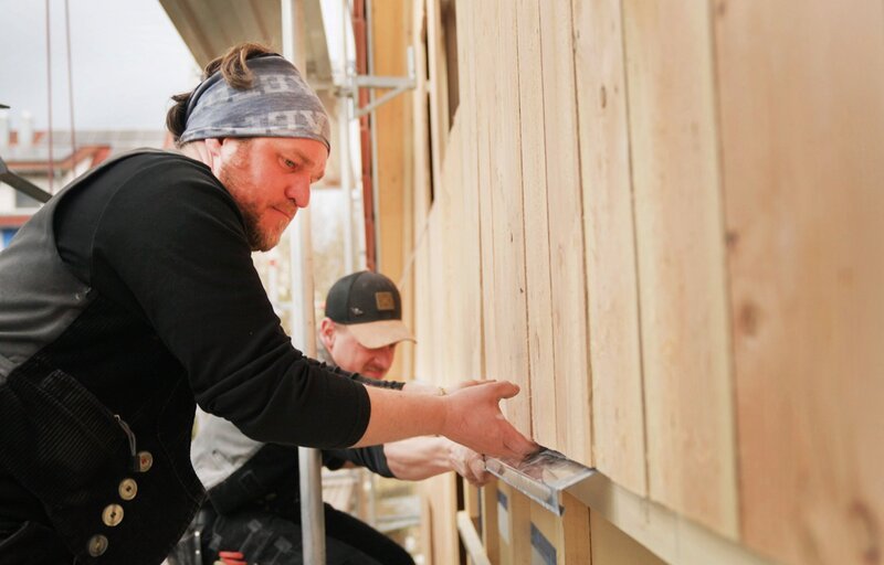 SWR HANDWERKSKUNST!, „Wie man ein Haus mit Holz verkleidet und dämmt“. Die Zimmermänner Stefan Sulga und Philipp Block bringen einen Etagenstross an. – Bild: SWR/​ Dirk Schwarz