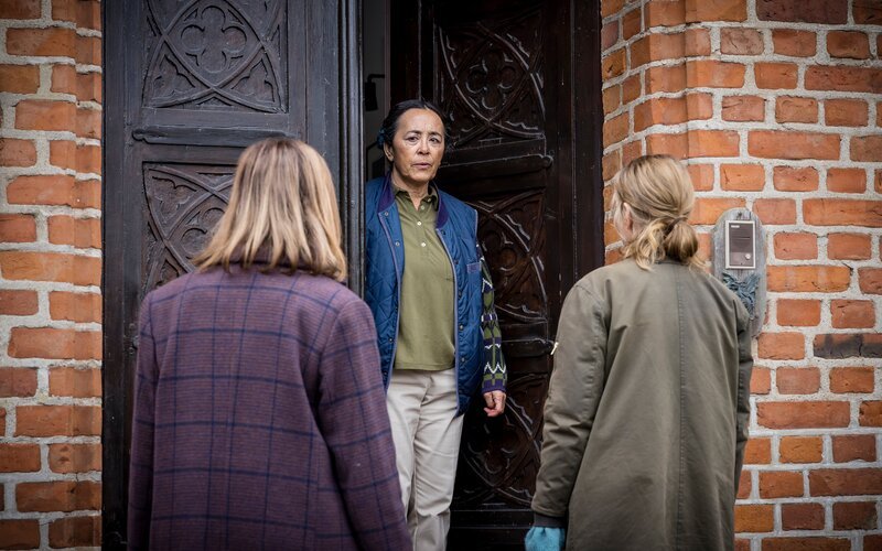 Haushälterin Fernanda (Ani Guiñez, M.) teilt Kerstin (Kajsa Ernst, l.) und Iris (Sofia Helin, r.) mit, dass sie nicht sofort mit Gutsbesitzerin Marianne sprechen können. – Bild: ZDF und Carolina Romare