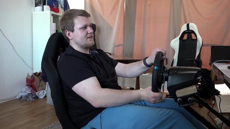 S13E82: Jean hat sich professionelles Equipment für seine Konsole gekauft, um zum Rennfahrer zu werden. Mit einem speziellen Autorennsitz, Lenkrad und Pedalen ausgestattet, erlebt er fast echte Rennsport-Action, wenn er digital über die Nordschleife fährt. – Bild: RTLZWEI