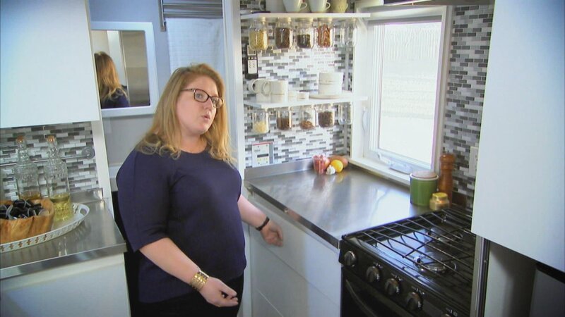 Als Lebensmittelwissenschaftlerin ist Ashley beruflich viel verreist und braucht ihr Haus gar nicht. Also vermietet sie es und wünscht sich stattdessen ein Tiny House. Dafür hat sie viel aussortiert und ist bereit, minimalistisch mit wenig Platz auszukommen. Ashleys beste Freundin Alice unterstützt sie bei der Suche nach einem modernen Mini-Haus mit ausreichend Platz zum Kochen und Gäste empfangen. Professionelle Hilfe bekommt Ashley von einem Freund – dem Makler Richard Rolfingsmeyer. Er zeigt ihr ein Cottage auf Rädern, einen umgebauten Lagercontainer und ein Musterhaus zum selbst gestalten. – Bild: HGTV