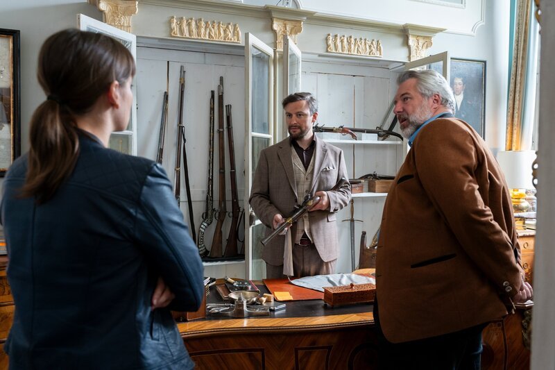 Die Kommissare Hecht (Thekla Hartmann, l.) und Stadler (Dieter Fischer, r.) befragen den Waffenexperten Phillipp von Zechenthal (Ben Akkaya, M.) zum Einbruch im Auktionshaus. – Bild: ORF/​ZDF/​Linda Gschwentner
