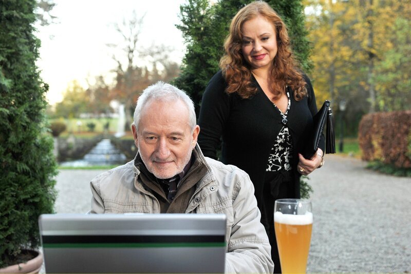 Magdalena (Petra Berndt, r.) sieht, wie Gustl (Sepp Schauer, l.) das Video einer Drehpanne von Alfons online stellt. – Bild: ARD/​Ann Paur