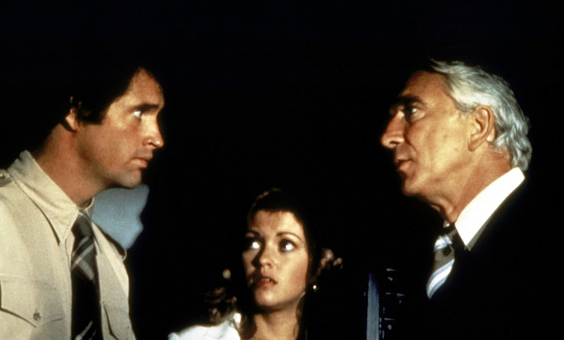 Weil der ehemalige Kampfpilot Ted Striker (Robert Hays, l.) unter Flugangst leidet, kann und will er Elaine (Julie Hagerty, M.) und Dr. Rumack (Leslie Nielsen, r.) nicht helfen, obwohl er der Einzige ist, der die Maschine landen könnte ... – Bild: Puls 8 Weil der ehemalige Kampfpilot Ted Striker (Robert Hays, l.) unter Flugangst leidet, kann und will er Elaine (Julie Hagerty, M.) und Dr. Rumack (Leslie Nielsen, r.) nicht helfen, obwohl er der Einzige ist, der die Maschine landen könnte ... – Bild: Puls 8