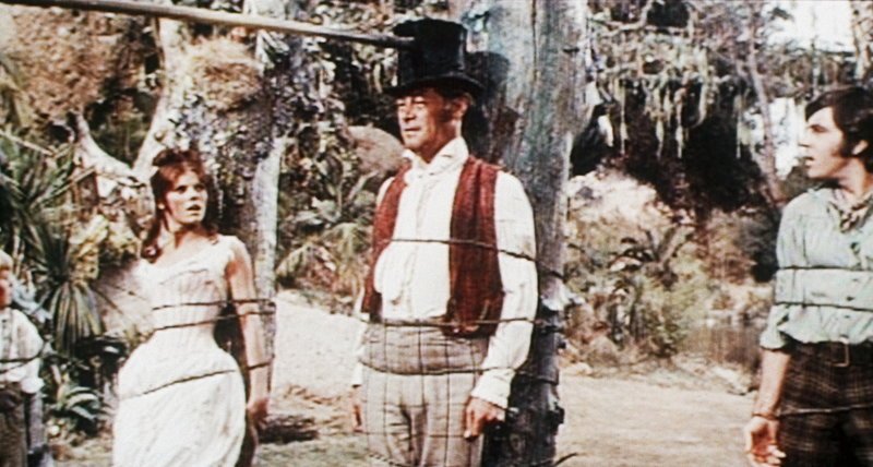 Auf ihrer Abenteuerreise werden Emma (Samantha Eggar, l.), Dolittle (Rex Harrison, M.) und Matthew (Anthony Newley, r.) von Eingeborenen gefangengenommen … – Bild: Puls 8