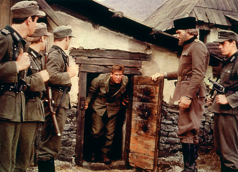 In der Gewalt der Deutschen: Harrison Ford als Lt. Colonel Mike Barnsby (M.), Richard Kiel als Capt. Drazak (2.v.r.) – Bild: SRF/American International Pictures, Inc. In der Gewalt der Deutschen: Harrison Ford als Lt. Colonel Mike Barnsby (M.), Richard Kiel als Capt. Drazak (2.v.r.) – Bild: SRF/American International Pictures, Inc.