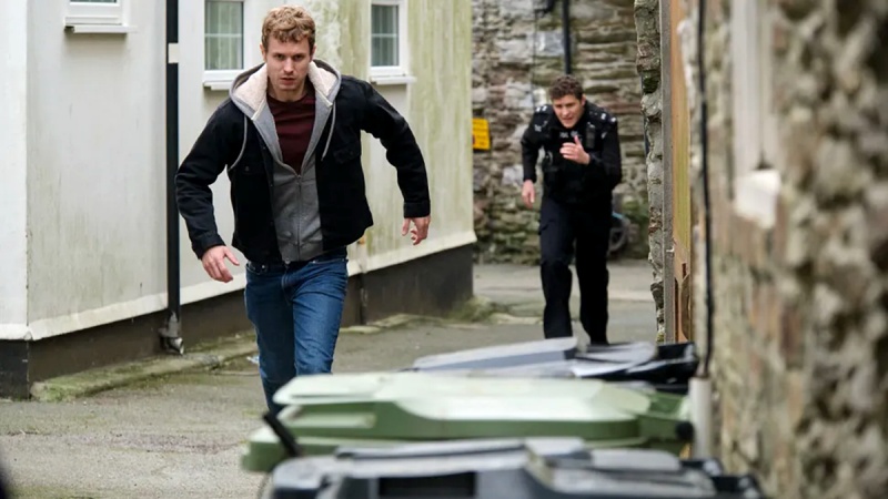 Josh Woods (Chris Jenks) will PC Kelby Hartford (Dylan Llewellyn) entkommen – Bild: BBC /​ Red Planet Pictures