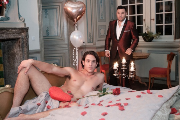 In der romantisch geschmückten Hochzeitssuite liegt ein (fremder) nackter Mann (Jacopo Garfagnoli) auf ihrem Bett – Easy (Lars Steinhöfel, r.) glaubt seinen Augen nicht zu trauen. Und der ungebetene, aber sehr attraktive Gast spricht nur italienisch! – Bild: TVNOW /​ Stefan Behrens