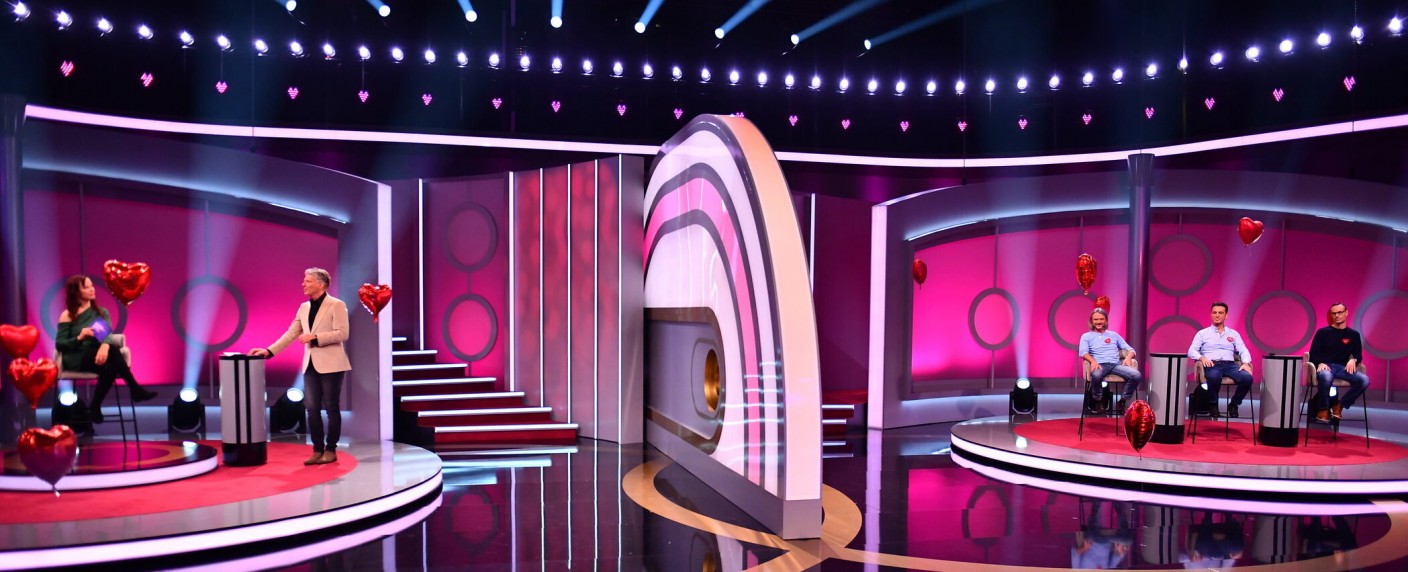 „Dating Game“, das „Herzblatt“ von Sat.1: Neuauflage der Flirtshow verheddert sich im Zeitgeist – Review – Pilawa, Susi, die Wand und auswendig gelernte Sprüche – Bild: Sat.1/​Julia Feldhagen